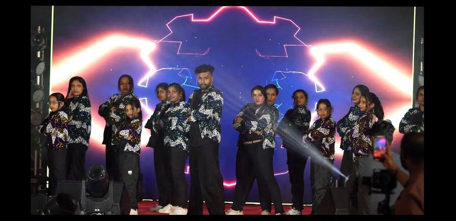 Dance crew posing on stage under dramatic lighting