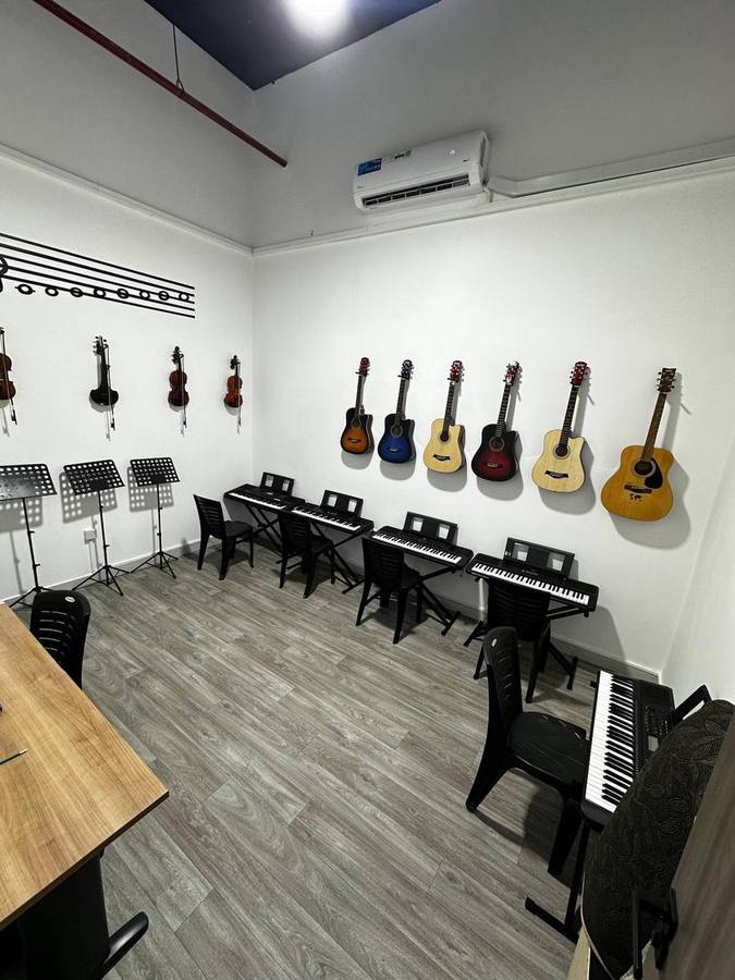 Wide view of the main practice room with guitars, violins, and keyboards