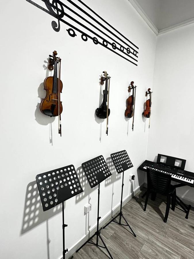 Violins mounted on the wall with a music-staff decal above
